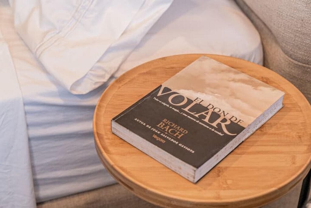 A book titled "Fleuron de Volar" by Richard Bach on a wooden stool.