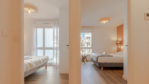 A hotel room with a bed, a desk, and a view of the outside. - Cassio (Annecy)