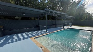 A swimming pool with a shaded deck area and a pergola structure. - Charming 1-bedroom apartment with WiFi, AC in gorgeous Sour Lake #211 (Sour Lake)