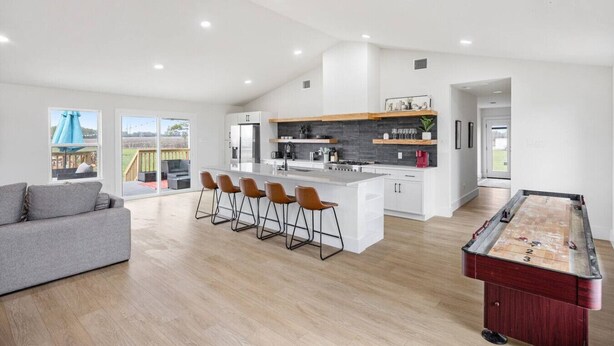 A modern kitchen with a central island, bar stools, and a pool table. - Bungalow on 3 Acres - Hot Tub& Firepit (McKinney)