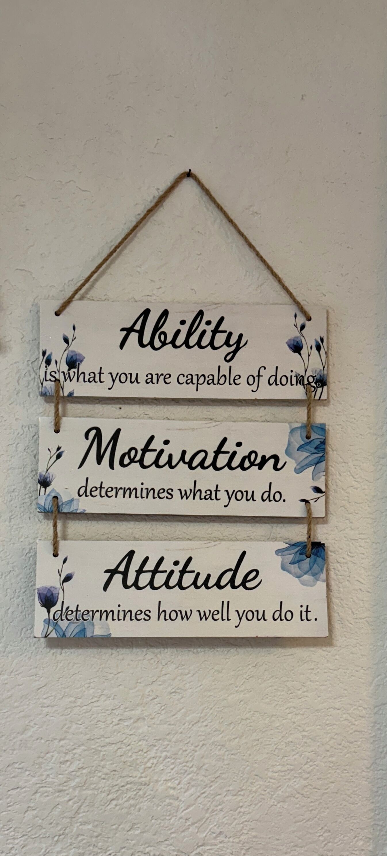 A motivational sign with three phrases: "Ability," "Motivation," and "Attitude," each followed by a brief explanation.