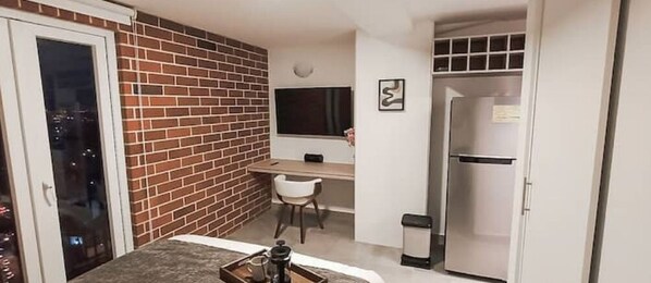 Een knus woongedeelte met een kitchenette, een eethoek en een kleine zithoek.
