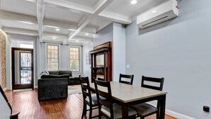 A dining area with a wooden table and chairs, a fireplace, and a large window.