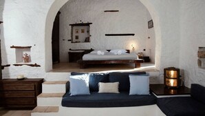 A cozy bedroom with a bed, a sofa, and a fireplace. - Historical Stone Manor-Upper Floor (Idra)