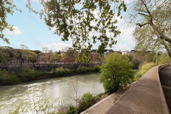 A river with a bridge and a pathway alongside it.