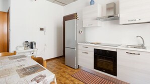 Een moderne keuken met een koelkast, oven en wastafel.