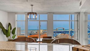 A kitchen with a large island, white walls, and large windows offering a view of the ocean and a bridge. - 2-bedroom apartment in brilliant Cleveland with WiFi, AC, fitness room (Cleveland)