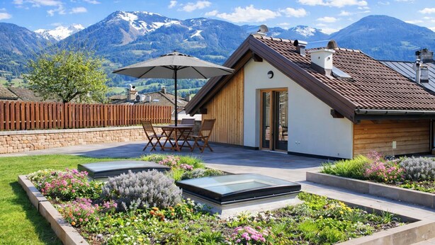 A modern house with a patio, wooden fence, and a mountain view. - Villa Cavazzal - Exclusive apartment (Cavalese)