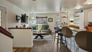 A modern kitchen with a central island, bar stools, and a dining area. - Dream 2-Story Home w/Deck, A/C, Hot Tub, Gas Grill, W/D - Walk to the Beach (San Diego)