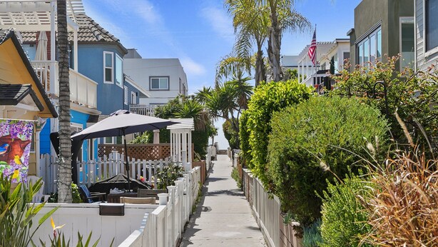 A narrow residential street lined with houses, a sidewalk, and lush greenery. - Dream 2-Story Home w/Deck, A/C, Hot Tub, Gas Grill, W/D - Walk to the Beach (San Diego)