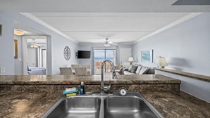 A modern kitchen with a large island, a built-in sink, and a view to the outside.