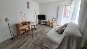 A modern living room with a sofa, a dining table with chairs, a TV, and a small cabinet. - CAP D'AGDE - Port Center // Ref 0142 (CAP D'AGDE)