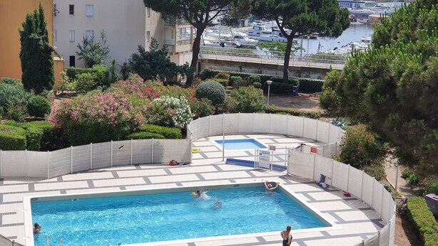 A swimming pool with a view of a marina and buildings in the background. - CAP D'AGDE - Port Center // Ref 0142 (CAP D'AGDE)