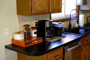 Una cocina con gabinetes de madera, una cafetera y un molinillo de café sobre la encimera.