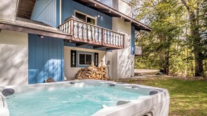 A hot tub in front of a house with a balcony. - Loose Moose Lodge – Family chalet, fireplace, ski! (Bartlett)
