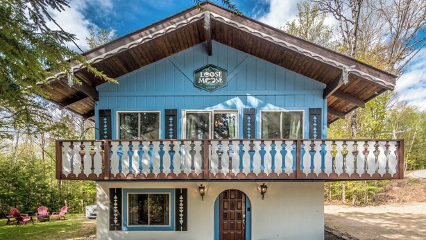 A blue lodge with a balcony, stone foundation, and a sign reading "LOOSE MOOSE LODGE". - Loose Moose Lodge – Family chalet, fireplace, ski! (Bartlett)
