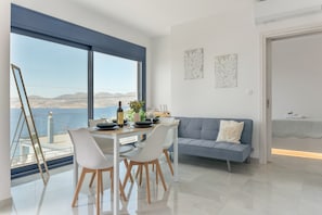 Une cuisine moderne avec une table à manger, des chaises et une vue sur la mer.