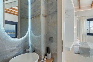 Un bagno moderno con un ampio specchio, una vasca da bagno e uno spazio doccia.