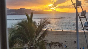 A beach with palm trees, a clear sky, and a sunset. - Vacation Studio 'Primera Linea' with Sea View, Balcony and Wi-Fi (Las Palmas de Gran Canaria)