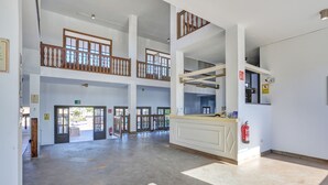 A spacious lobby with a high ceiling, multiple doors, and a fire extinguisher. - 'VV Oasis Duna Punto Alegre' Vacation with Shared Pool, Private Terrace, and Wi-Fi (Corralejo)