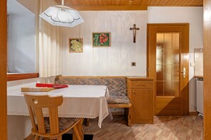 A dining area with a wooden table, bench, and a wooden cabinet.