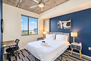 A hotel room with a bed, bedside tables, a desk, and a chair. - CDT PHX Apt Balcony Gym Pool WD & Parking (Phoenix)