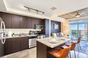 A modern kitchen with dark cabinetry, stainless steel appliances, and a granite countertop. - CDT PHX Apt Balcony Gym Pool WD & Parking (Phoenix)