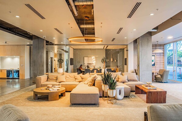 A spacious lobby with a large sectional sofa, a coffee table, and a potted plant.