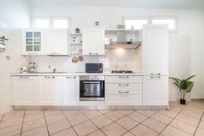 A modern kitchen with white cabinetry, a built-in oven, and a microwave.
