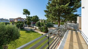 Un quartier résidentiel doté d’un chemin pavé, d’une clôture en bois et de divers arbres.