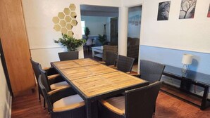A dining area with a wooden table and black wicker chairs.