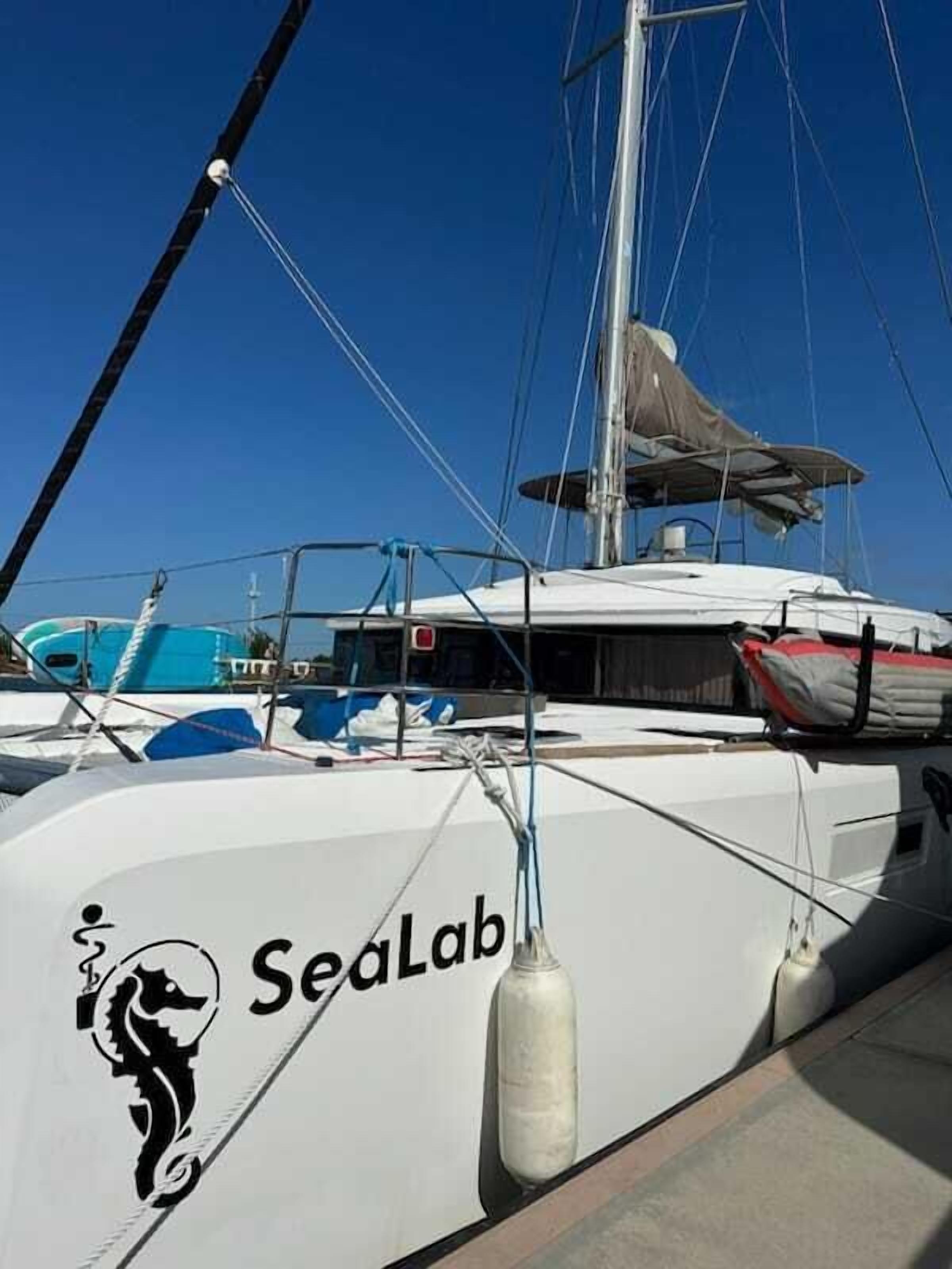 A white yacht with the logo "Sealab" and a seahorse emblem.