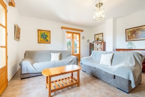 Una sala de estar con dos sofás, una mesa de centro de madera y una estantería.