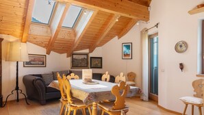 A dining area with a wooden table, chairs, and a ceiling with skylights.