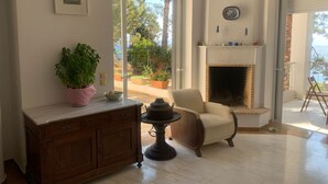 Una sala de estar con chimenea, un sofá, un aparador de madera y una planta en maceta.