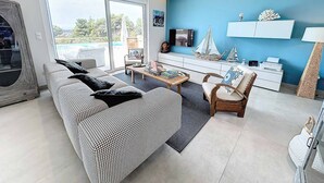 En moderne stue med sofa, sofabord og pynt.