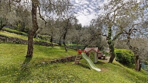 A playground with a slide and climbing structures, surrounded by trees and grass. - Apartment 'Edda - Sole' with Lake View, Private Terrace, and Wi-Fi (Brenzone sul Garda)