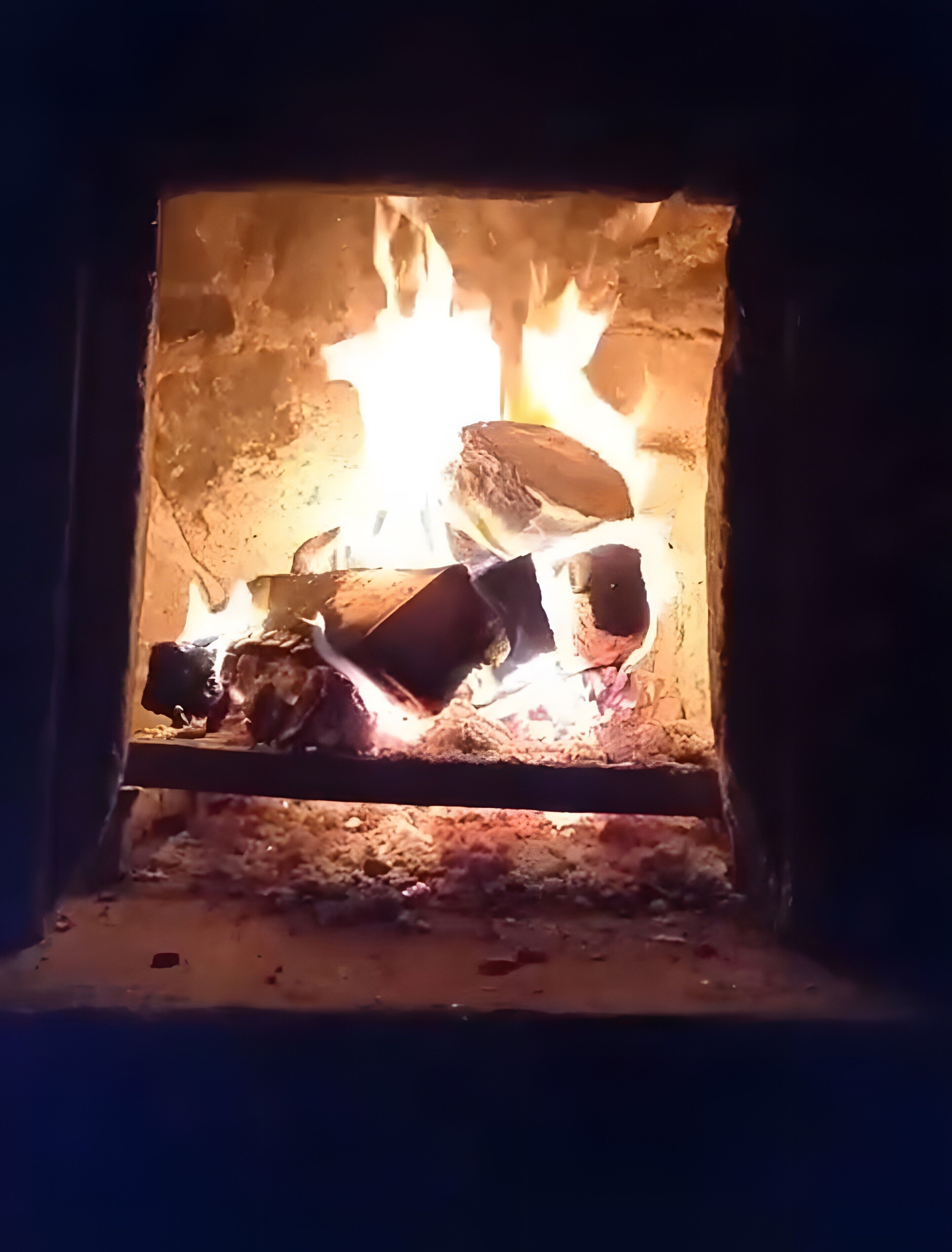 Ein Kamin mit brennenden Holzscheiten.
