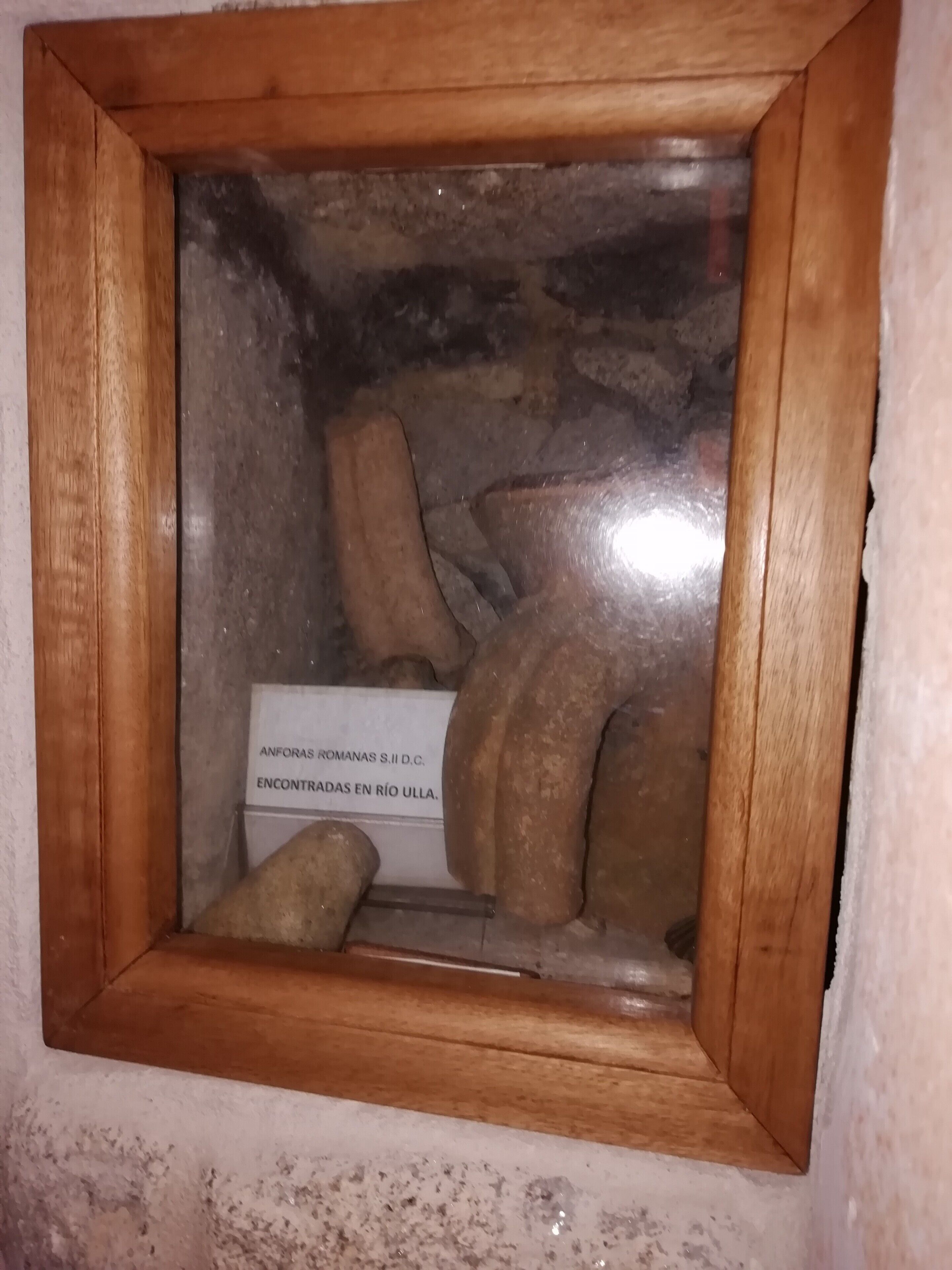 Vitrina con una colección de artefactos romanos etiquetada como 'ANFORAS ROMANAS S.II D.C. ENCONTRADAS EN RÍO ULLA'.