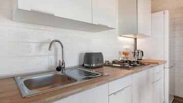 Frigorífico, placa de cocina, cafetera o tetera y utensilios de cocina