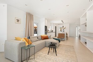 A modern living room with a sectional sofa, a small table, and a kitchen in the background.