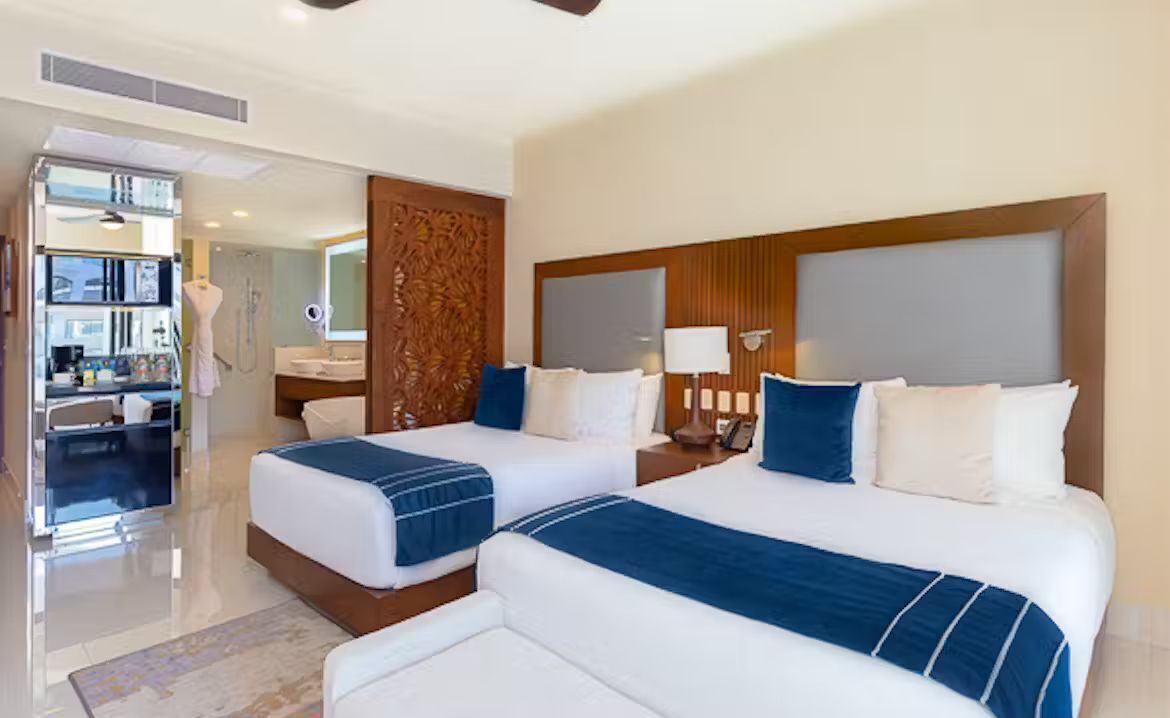 Une chambre d’hôtel avec deux lits, une salle de bain et une kitchenette.