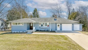 A single-story house with a front porch, a garage, and a small yard.