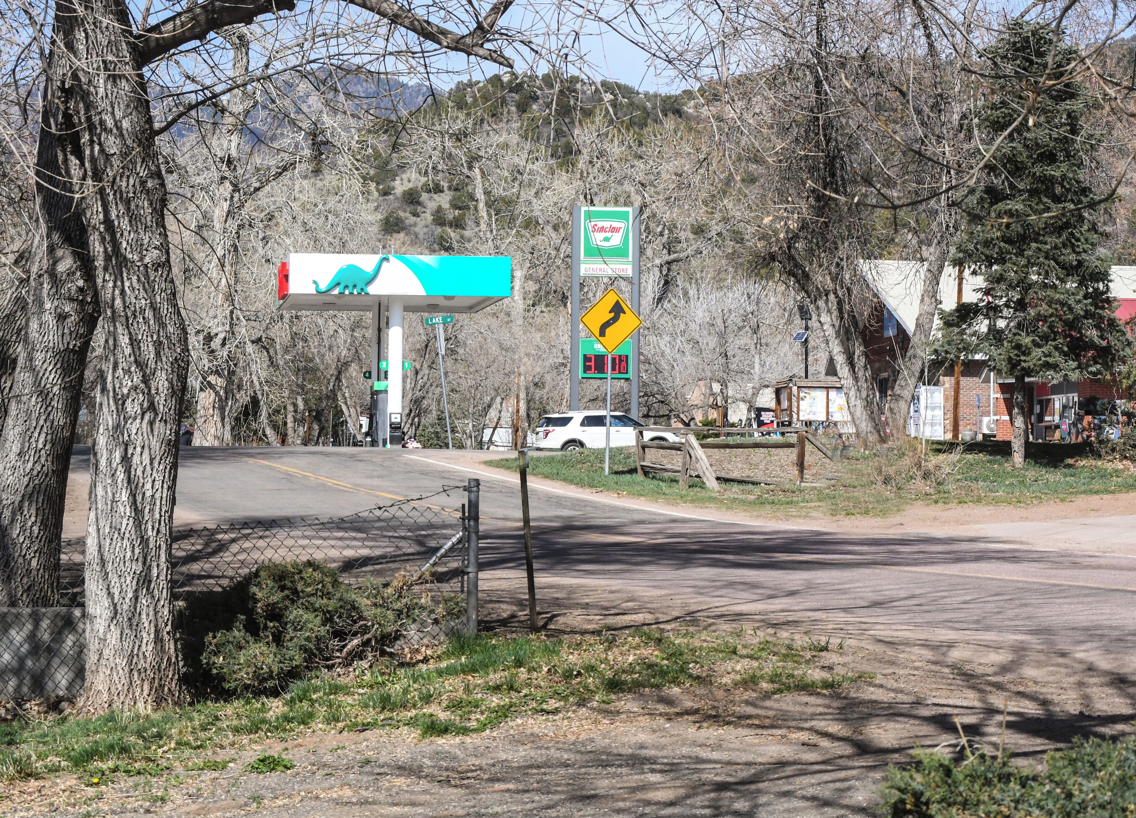 Una estación de servicio con el letrero de Chevron, un cartel de límite de velocidad y un indicador direccional hacia Lake Ave.