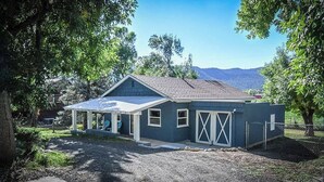 Einbungalow mit überdachter Veranda, Garage und eingezäunter Garten.