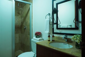 A bathroom with a shower, toilet, sink, and mirror. - Torre Sevilla by The Local Way (Mexico City)