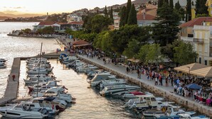 Un port de plaisance où de nombreux bateaux sont amarrés le long d’une promenade en bord de mer.