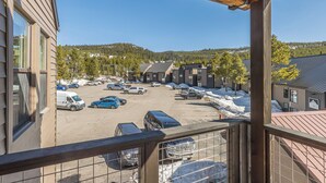 Un parking avec plusieurs voitures et, au fond, un bâtiment doté d’un toit en pente.