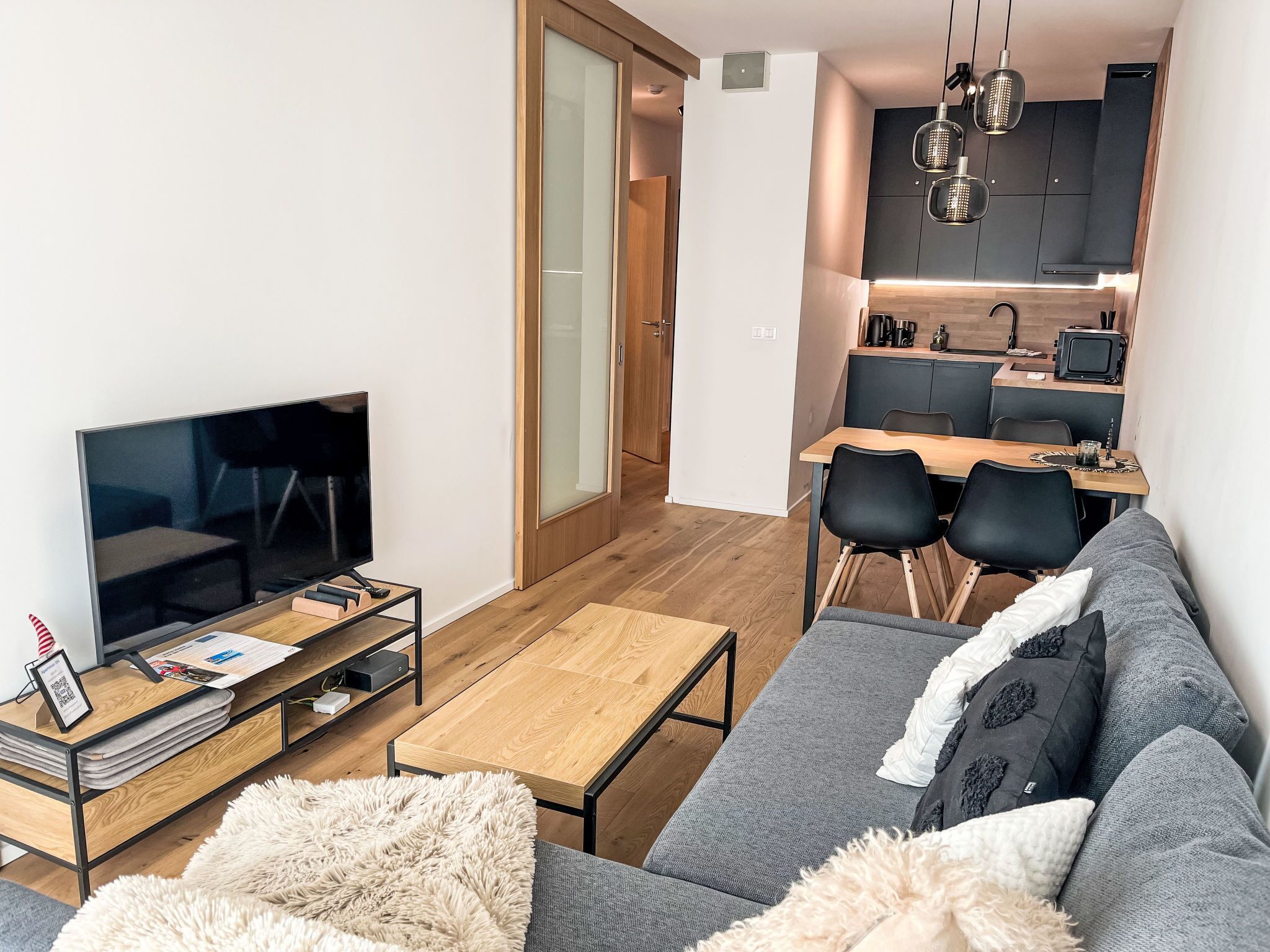 A modern living room with a TV, sofa, and coffee table.