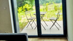 Una habitación con un amplio ventanal corredera que da a un patio exterior con una mesa y sillas.